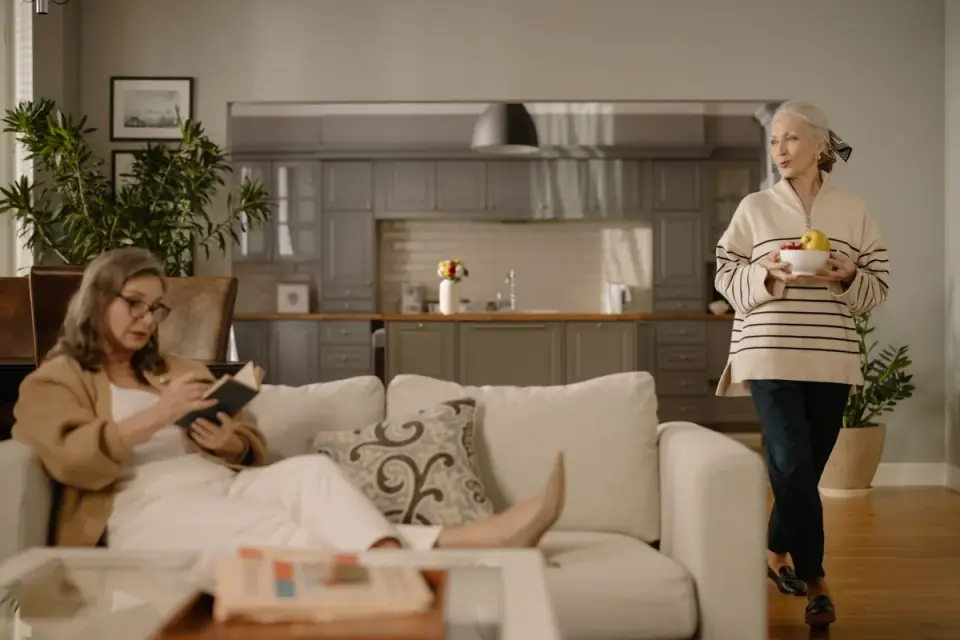 A dog owner reading a supplement label in the kitchen next to her senior dog