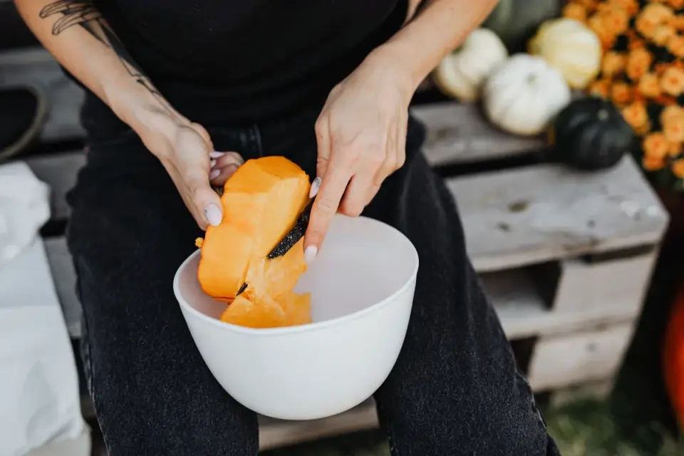 A veterinarian spooning pumpkin puree into a dog&#x27;s food bowl