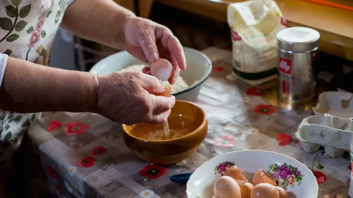 Senior dog standing at a bowl in a home kitchen